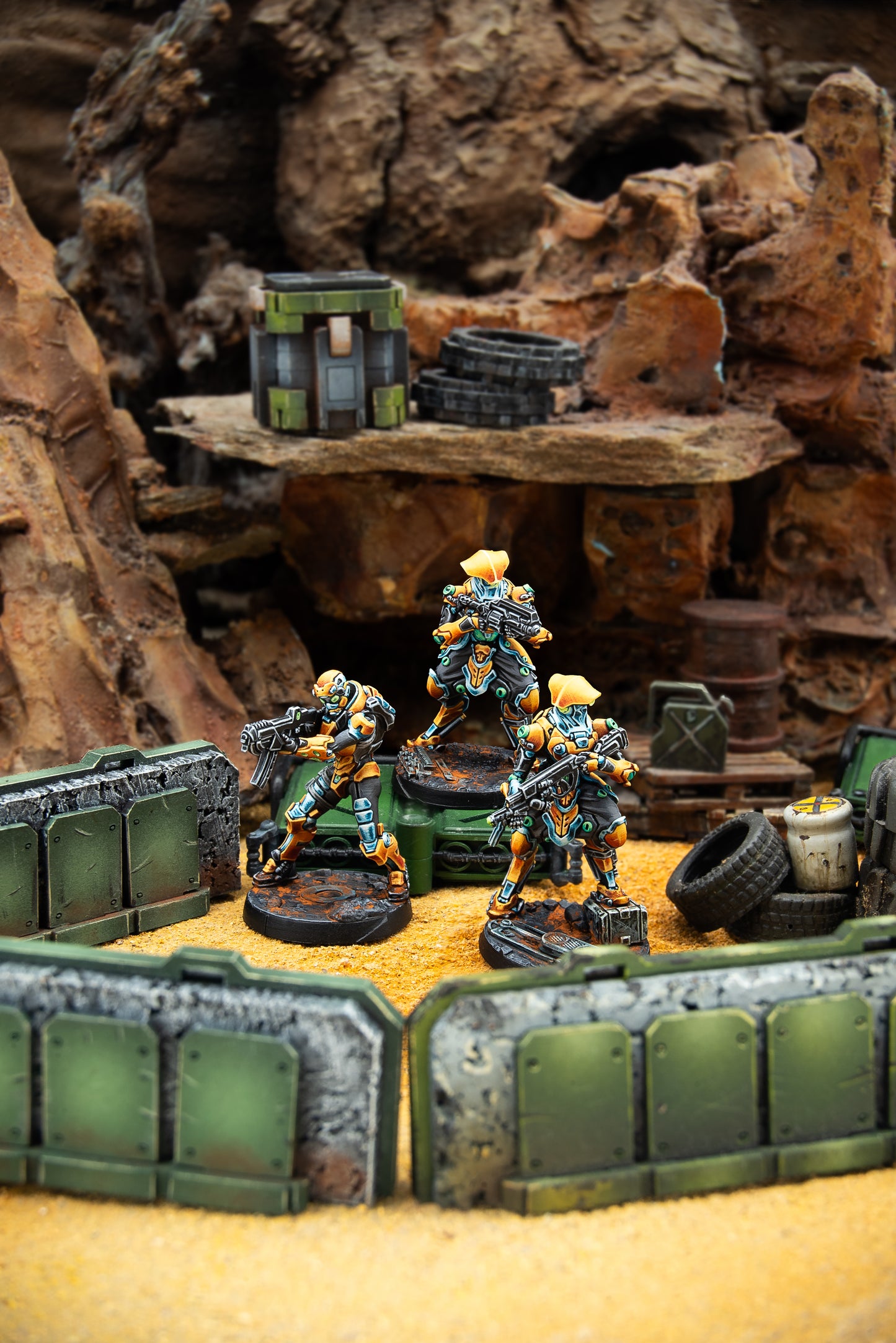 Miniature figures in a desert-like setting with rocks and crates