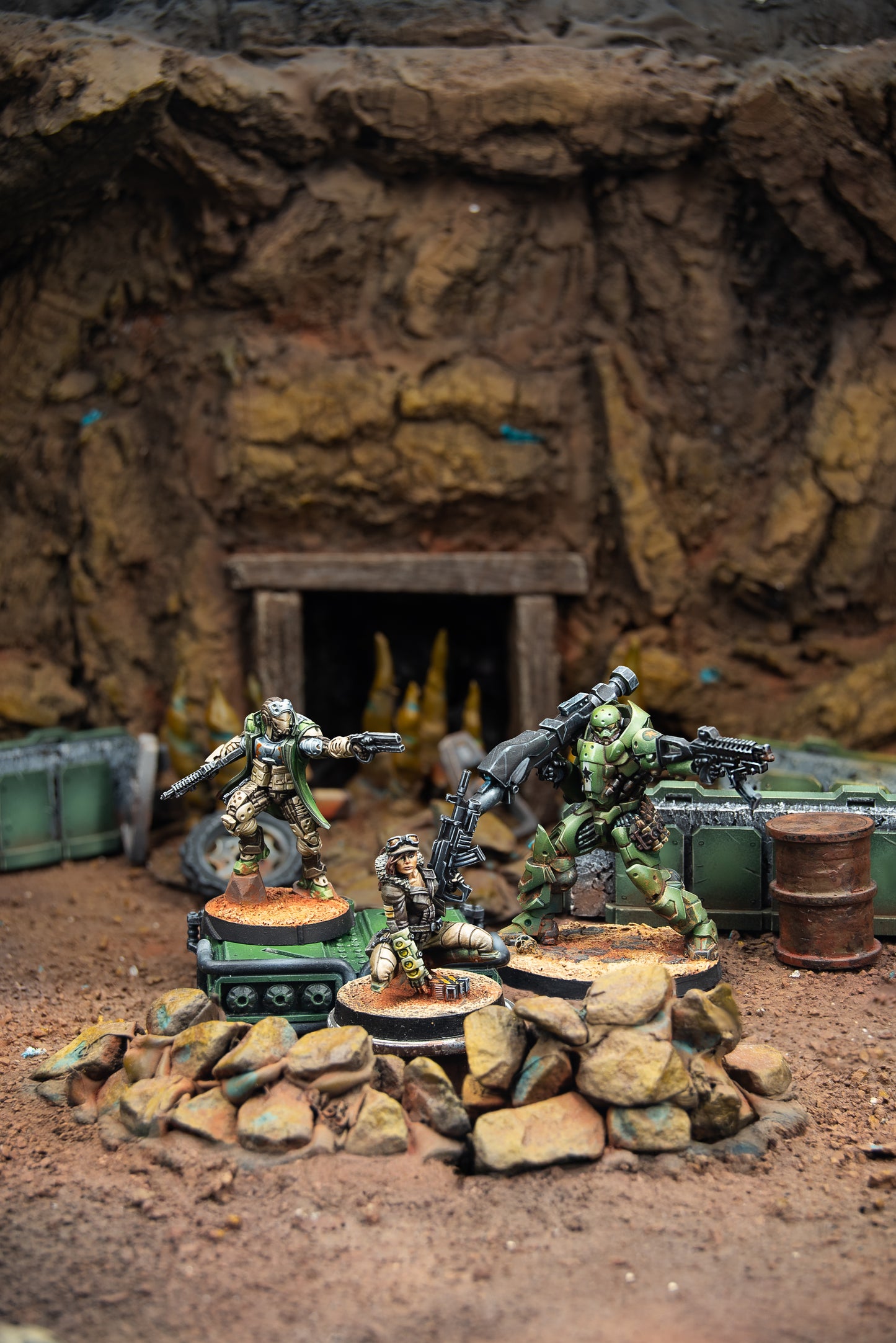 Miniature figures in a diorama setting with rocky terrain and cave-like background