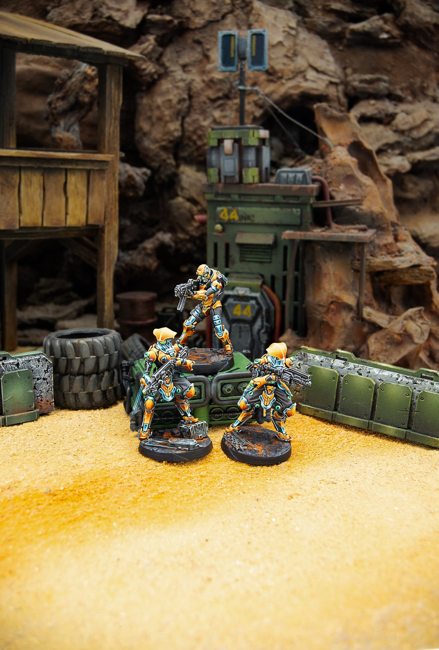 Miniature figures on a desert-like terrain with rocky background