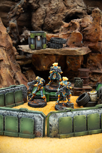 Miniature figures in a desert-like setting with rocks and crates
